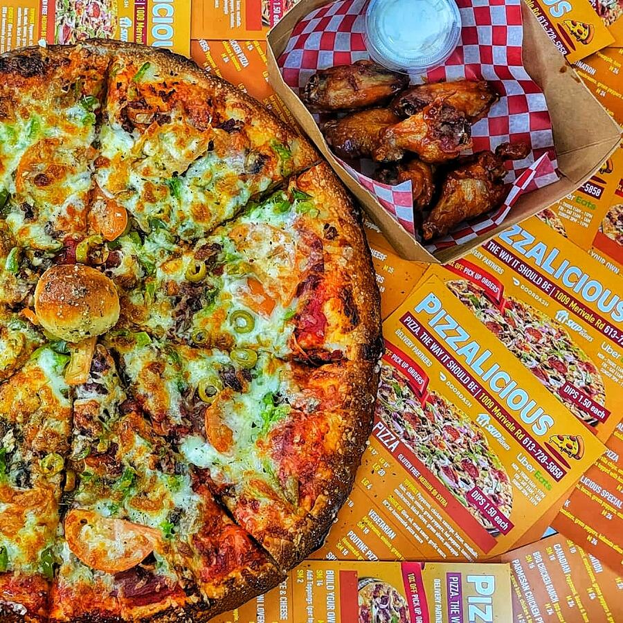 Pizzalicious pizza and wings laid out together for dinner